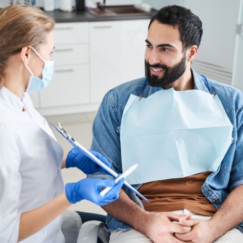 Man in the dental chair listening intently to his dentist